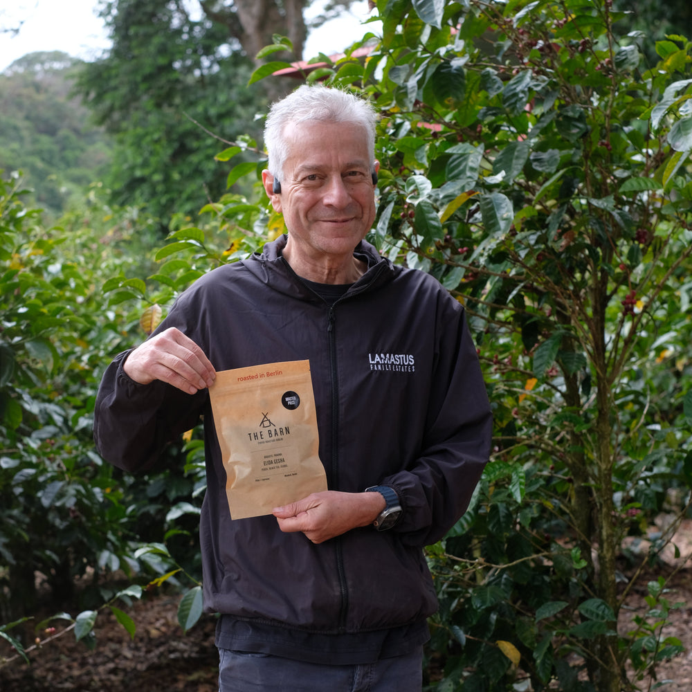 Coffee farmer holding a coffee package in a coffee plantation